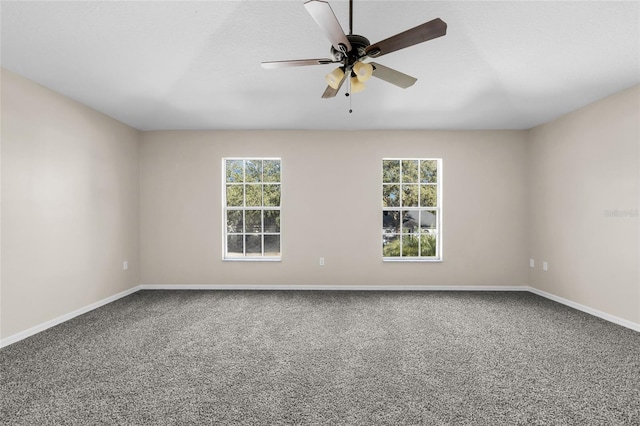 carpeted spare room featuring ceiling fan and a healthy amount of sunlight