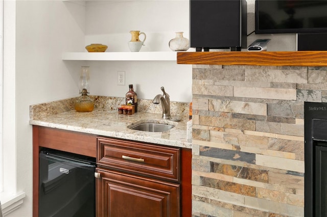 bar featuring light stone countertops, sink, and dishwashing machine