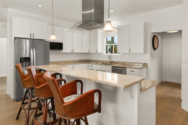 kitchen featuring pendant lighting, a center island, a kitchen breakfast bar, white cabinetry, and island exhaust hood