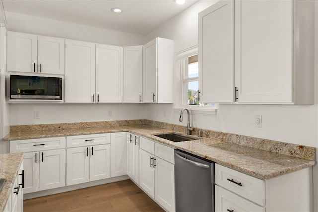 kitchen featuring white cabinetry, sink, stainless steel appliances, and light hardwood / wood-style flooring