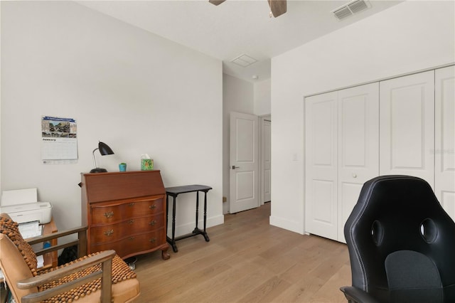 office with light hardwood / wood-style flooring and ceiling fan