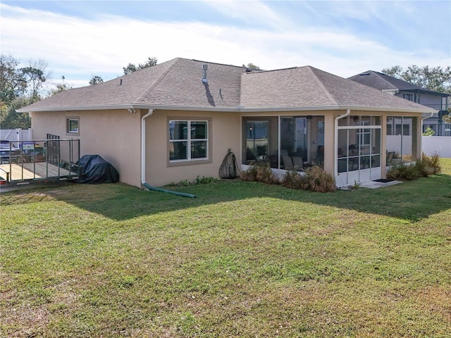 rear view of house with a yard and a sunroom