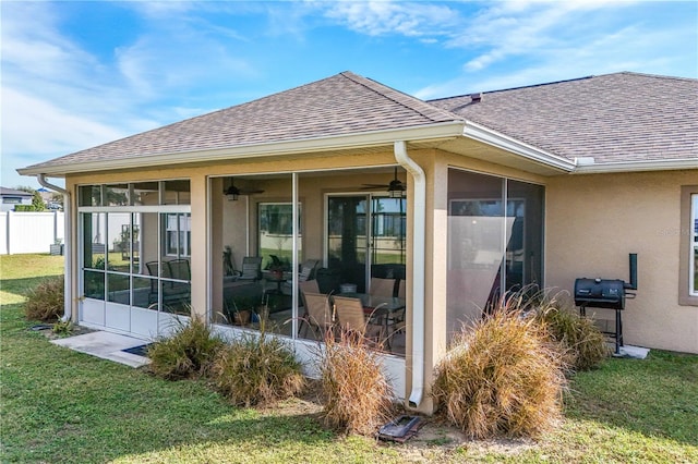 rear view of property featuring a lawn and a sunroom