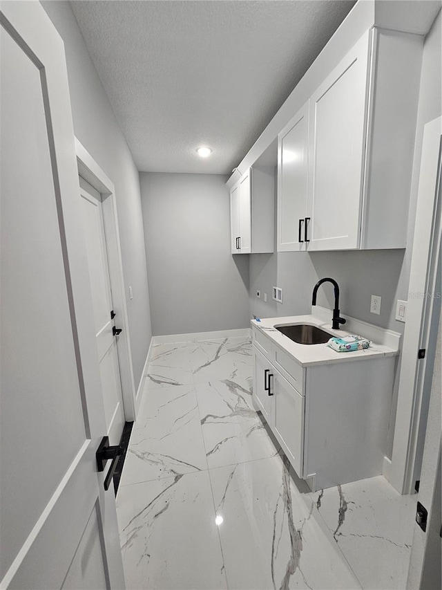 42157 Tamarac St, Eustis, FL 32736 - laundry room featuring hookup for a washing machine, marble finish flooring, baseboards, a textured ceiling, and cabinet space
