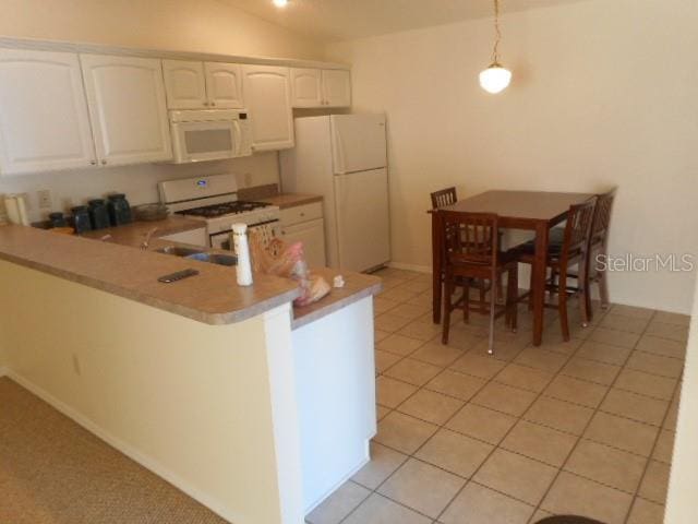 kitchen featuring hanging light fixtures, light tile patterned floors, kitchen peninsula, white appliances, and white cabinets