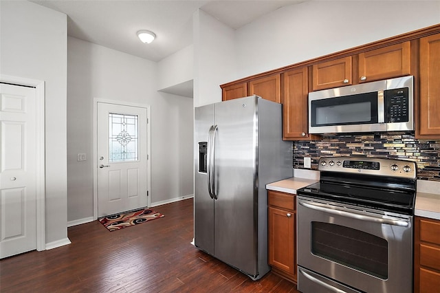 kitchen with appliances with stainless steel finishes, backsplash, and dark hardwood / wood-style flooring