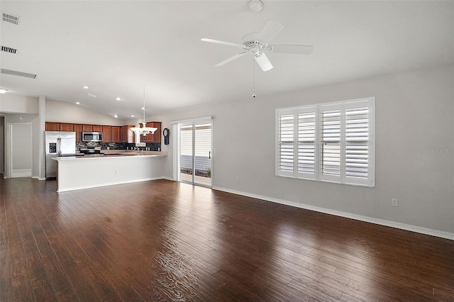 unfurnished living room with ceiling fan with notable chandelier, dark wood-type flooring, and lofted ceiling