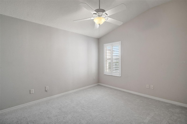 carpeted spare room featuring ceiling fan and vaulted ceiling