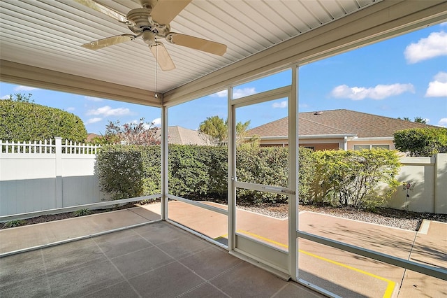 unfurnished sunroom with ceiling fan