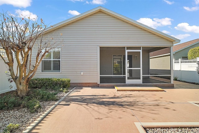 rear view of property featuring a patio and a sunroom