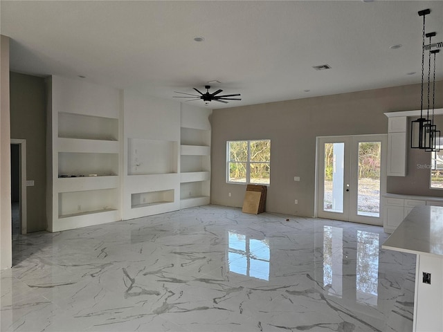 unfurnished living room with visible vents, built in shelves, marble finish floor, french doors, and ceiling fan