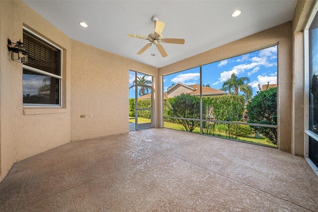 unfurnished sunroom featuring ceiling fan