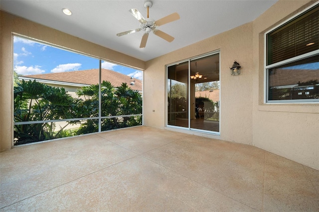 unfurnished sunroom featuring a ceiling fan