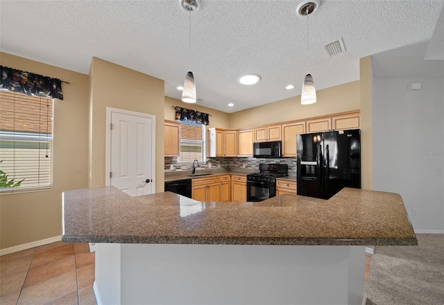 kitchen featuring visible vents, decorative backsplash, light brown cabinetry, black appliances, and a sink