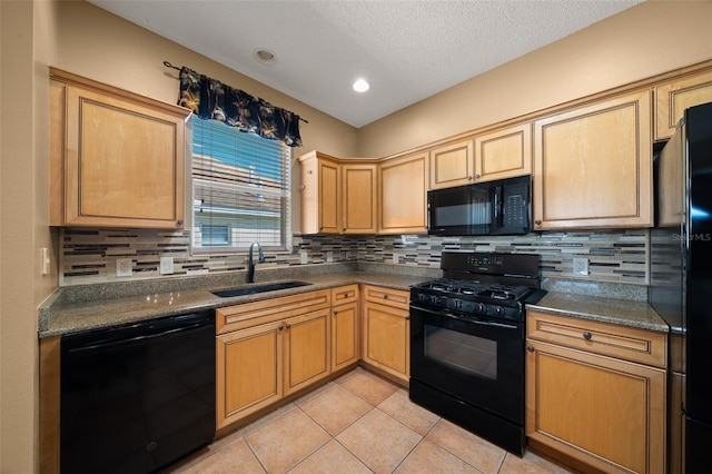 kitchen with light tile patterned floors, decorative backsplash, a textured ceiling, black appliances, and a sink