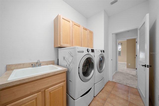 clothes washing area featuring cabinet space, light tile patterned floors, visible vents, independent washer and dryer, and a sink