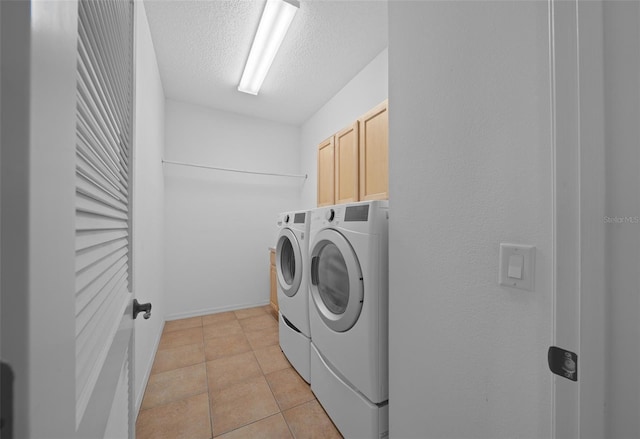 clothes washing area with cabinet space, light tile patterned flooring, a textured ceiling, and independent washer and dryer