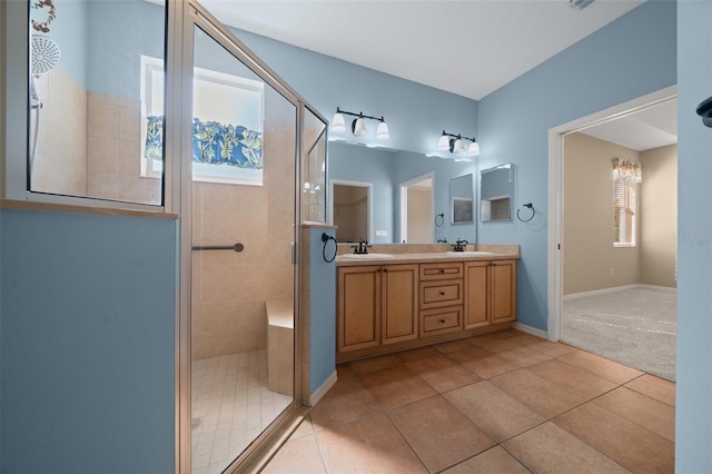 full bathroom with a sink, double vanity, a shower stall, and tile patterned floors