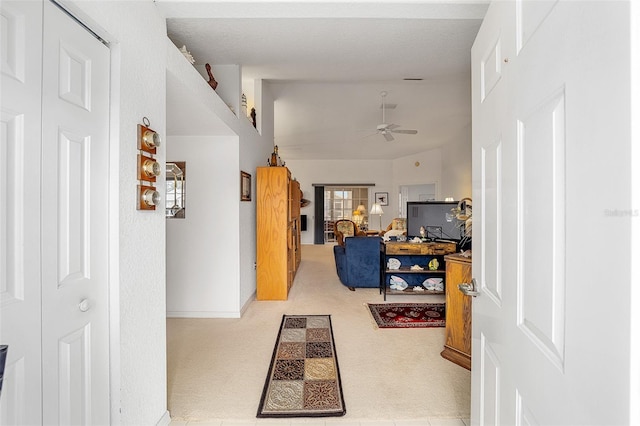 corridor featuring light carpet and vaulted ceiling