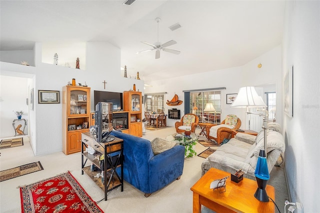 carpeted living room with ceiling fan and high vaulted ceiling