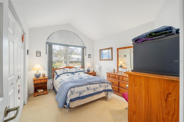 bedroom with light colored carpet and lofted ceiling