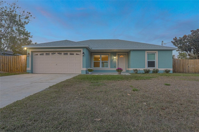 ranch-style house with a garage and a yard