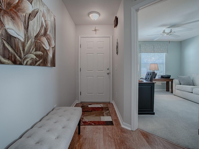 doorway to outside with ceiling fan and light hardwood / wood-style floors