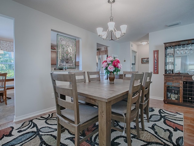 dining space featuring light hardwood / wood-style floors and an inviting chandelier