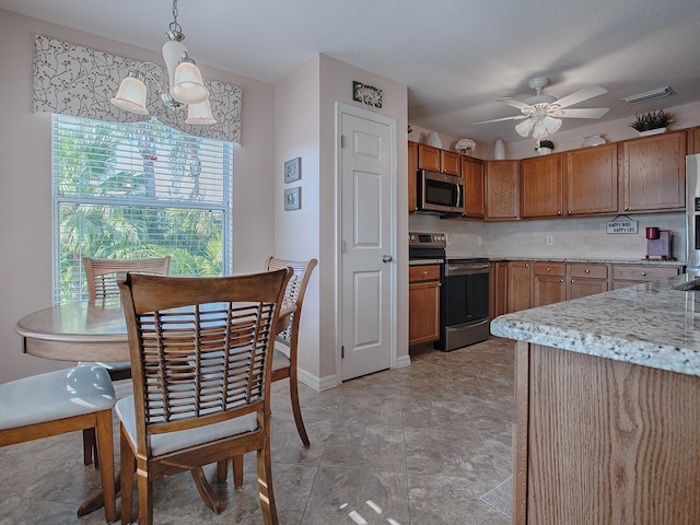 kitchen featuring stainless steel appliances, ceiling fan with notable chandelier, backsplash, and hanging light fixtures