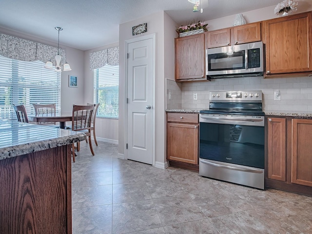 kitchen with decorative backsplash, stainless steel appliances, pendant lighting, and a chandelier