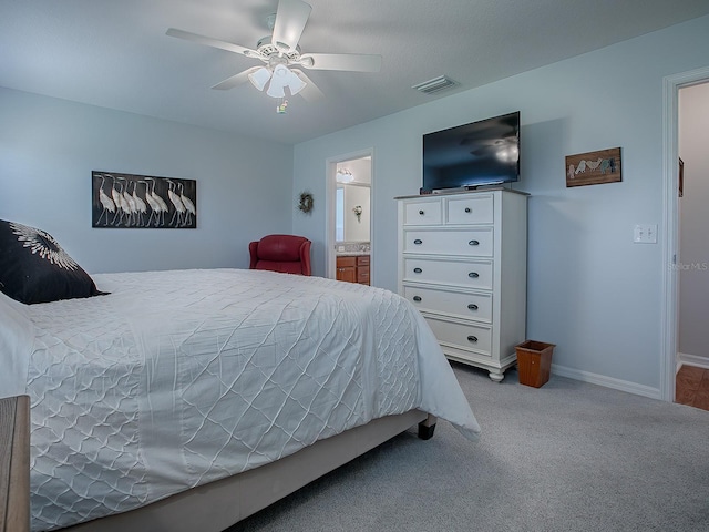 carpeted bedroom featuring ceiling fan and ensuite bath