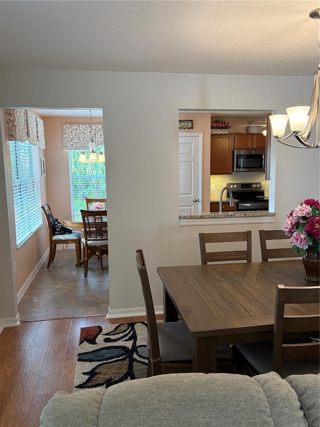 dining room featuring sink, a notable chandelier, and dark hardwood / wood-style flooring