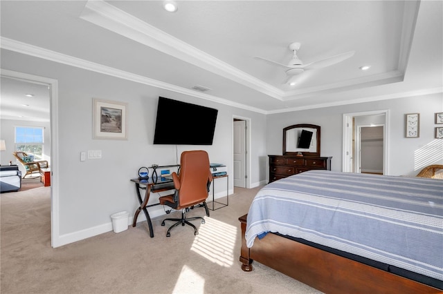 carpeted bedroom with a closet, a tray ceiling, ceiling fan, and ornamental molding