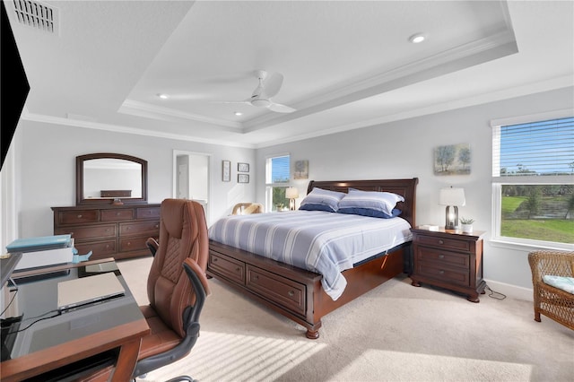 carpeted bedroom featuring ceiling fan, ornamental molding, multiple windows, and a tray ceiling