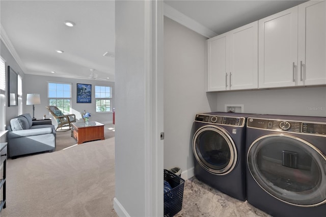 laundry area featuring ceiling fan, cabinets, separate washer and dryer, crown molding, and light colored carpet