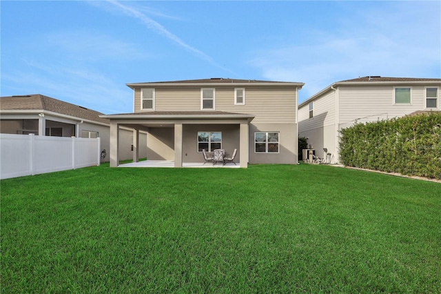 rear view of house featuring a lawn and a patio