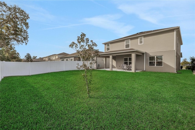 rear view of house with a lawn and a patio area