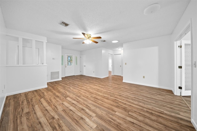 unfurnished living room with hardwood / wood-style flooring, ceiling fan, and a textured ceiling