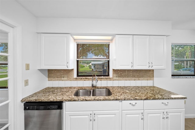 kitchen with decorative backsplash, sink, dark stone countertops, dishwasher, and white cabinetry