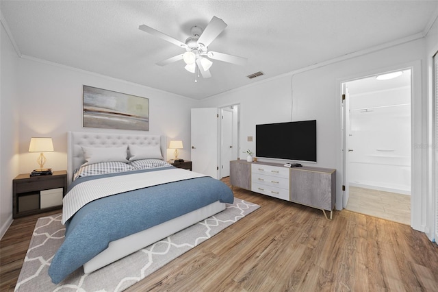 bedroom featuring crown molding, ceiling fan, ensuite bathroom, and wood-type flooring