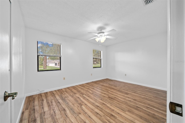 spare room with ceiling fan, hardwood / wood-style floors, and a textured ceiling