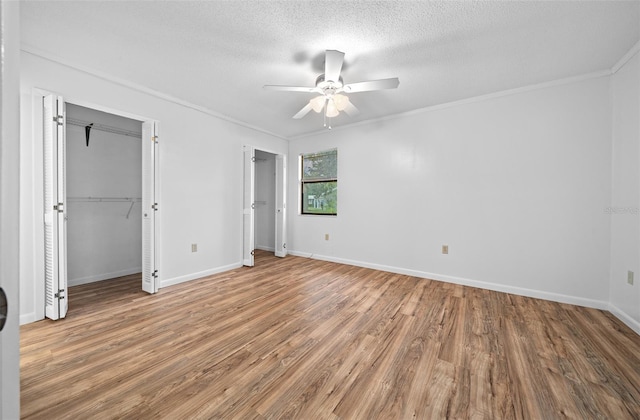 unfurnished bedroom with ceiling fan, crown molding, a textured ceiling, and hardwood / wood-style flooring