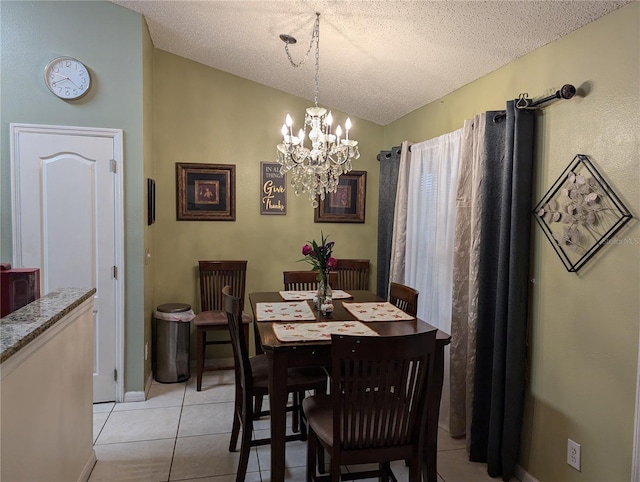 tiled dining area featuring a textured ceiling, an inviting chandelier, and vaulted ceiling