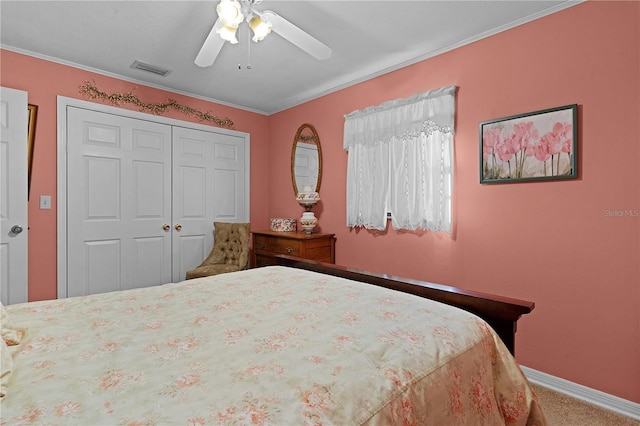 carpeted bedroom with a closet, ceiling fan, and ornamental molding