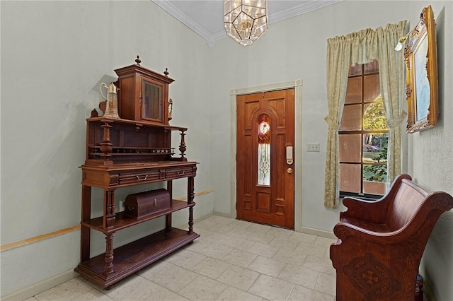 foyer entrance with ornamental molding and a chandelier