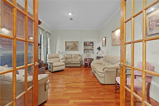 living room with french doors, light wood-type flooring, and crown molding