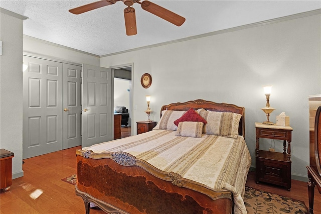 bedroom featuring crown molding, hardwood / wood-style flooring, ceiling fan, a textured ceiling, and a closet