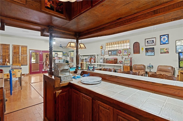 kitchen featuring tile countertops, crown molding, french doors, and pendant lighting