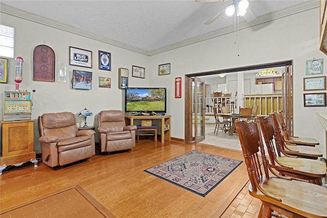 living area with ceiling fan, crown molding, and hardwood / wood-style floors