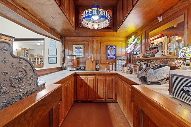 bar featuring pendant lighting, tile countertops, and wooden walls